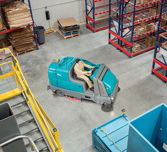 Une machine Tennant nettoyant le plancher d’un établissement Une machine Tennant nettoyant le plancher d’un établissement